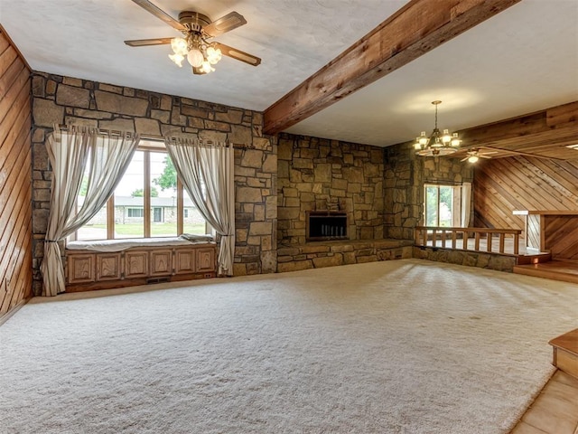 1501 S Avery Ave, Midwest City, OK 73130 - unfurnished living room featuring wooden walls, a ceiling fan, a chandelier, beamed ceiling, and light carpet