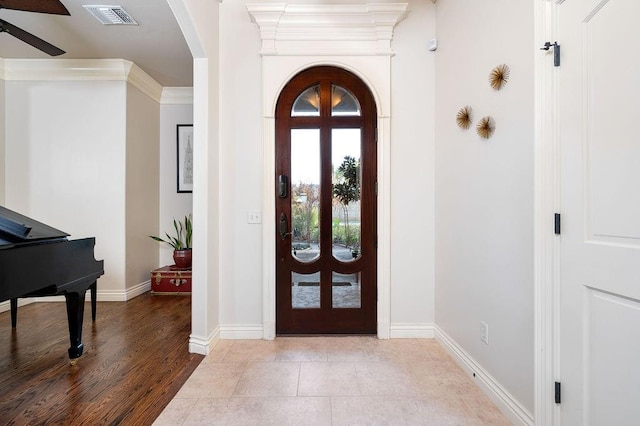 entrance foyer with french doors, light hardwood / wood-style flooring, and ornamental molding