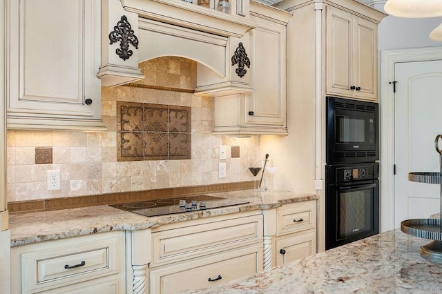 kitchen featuring cream cabinetry, tasteful backsplash, light stone counters, and black appliances