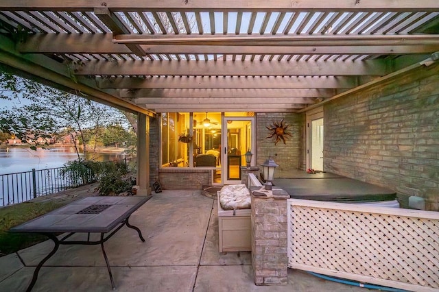 view of patio / terrace featuring a pergola and a water view