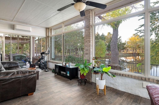 sunroom featuring a wall mounted air conditioner, radiator heating unit, a water view, and ceiling fan