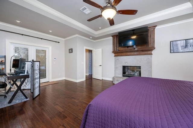 bedroom featuring crown molding, a fireplace, ceiling fan, and dark wood-type flooring