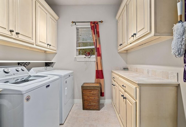 laundry area featuring washer and clothes dryer, cabinets, and light tile patterned floors