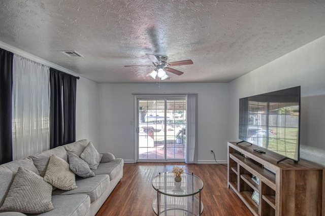 living room featuring a textured ceiling, ceiling fan, and dark wood-type flooring