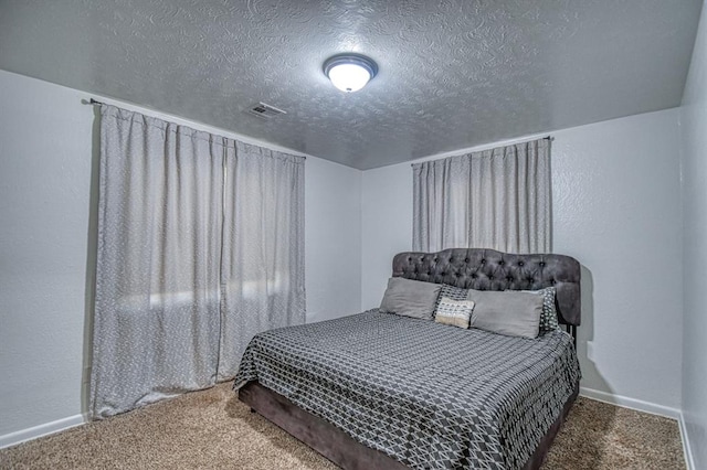 bedroom featuring carpet flooring and a textured ceiling