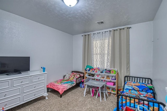 carpeted bedroom featuring a textured ceiling