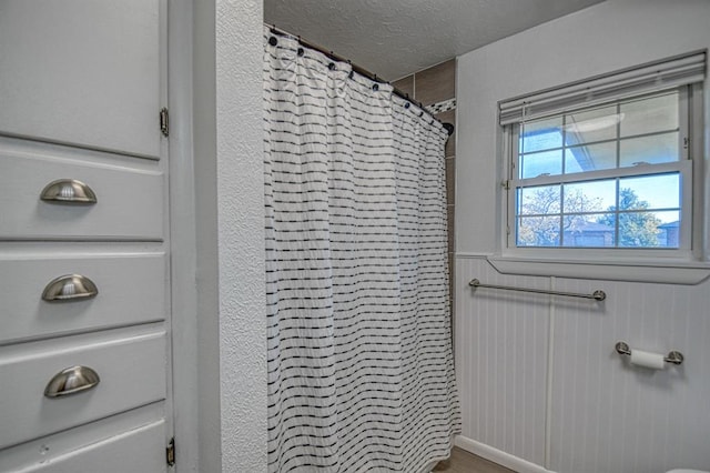 bathroom with a textured ceiling and walk in shower