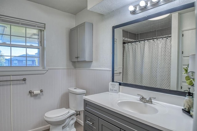 bathroom featuring a shower with curtain, vanity, and toilet