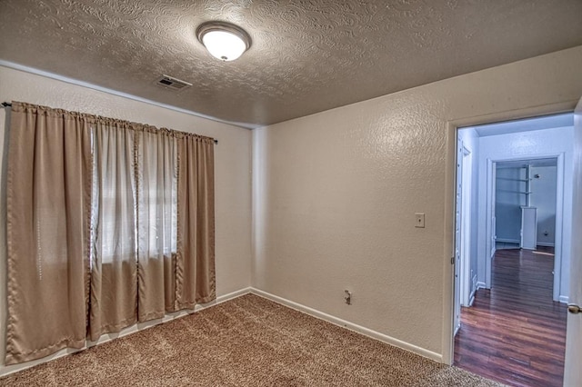 carpeted spare room with a textured ceiling