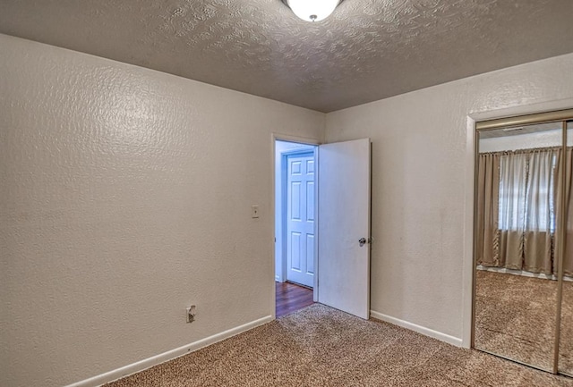 carpeted spare room featuring a textured ceiling