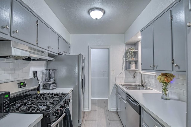 kitchen featuring decorative backsplash, a textured ceiling, stainless steel appliances, sink, and light tile patterned floors