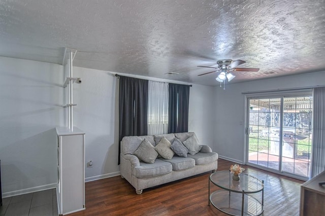 living room featuring a textured ceiling, ceiling fan, and dark hardwood / wood-style floors