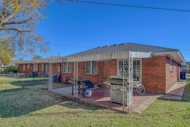 rear view of property with a yard, a patio area, and central air condition unit