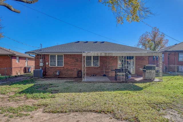 rear view of property with a lawn, central air condition unit, and a patio