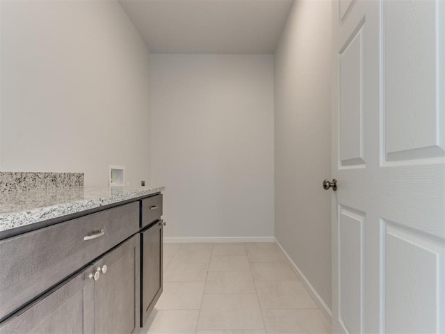 washroom with electric dryer hookup, light tile patterned flooring, cabinets, and hookup for a washing machine