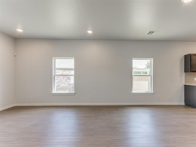 spare room with a wealth of natural light and light hardwood / wood-style flooring