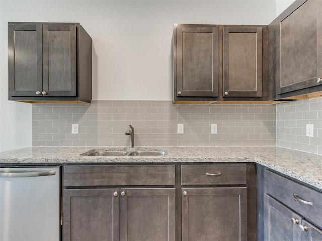 kitchen with dark brown cabinetry, light stone countertops, dishwasher, and sink