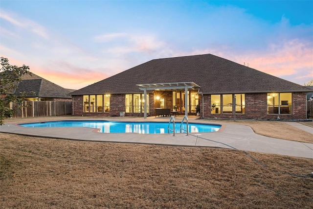 pool at dusk with a pergola and a patio