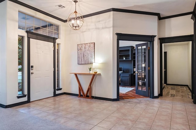 tiled entrance foyer with a chandelier and ornamental molding