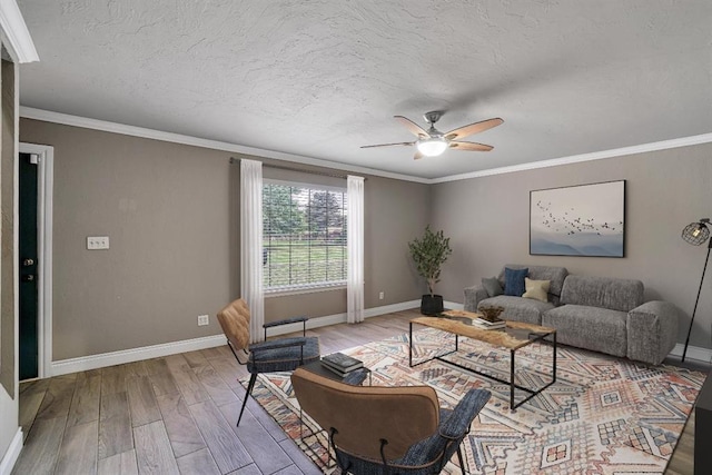 living room with ceiling fan, ornamental molding, and light hardwood / wood-style flooring