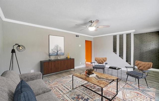 living room featuring crown molding, light hardwood / wood-style flooring, and ceiling fan