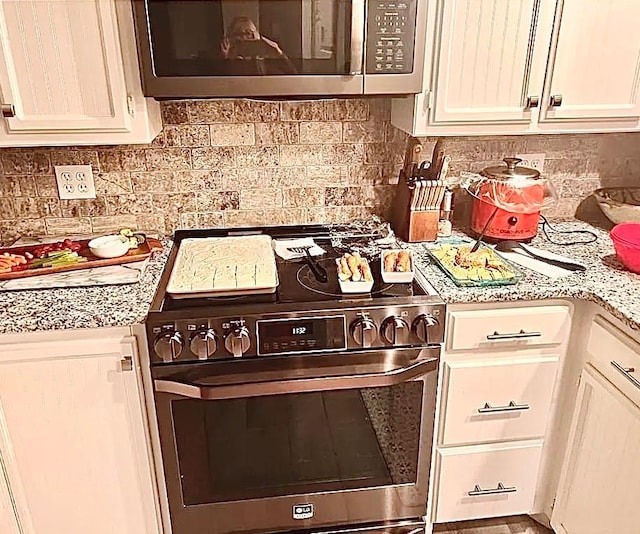 kitchen featuring stainless steel appliances and tasteful backsplash