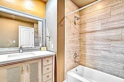 bathroom featuring vanity and tiled shower / bath