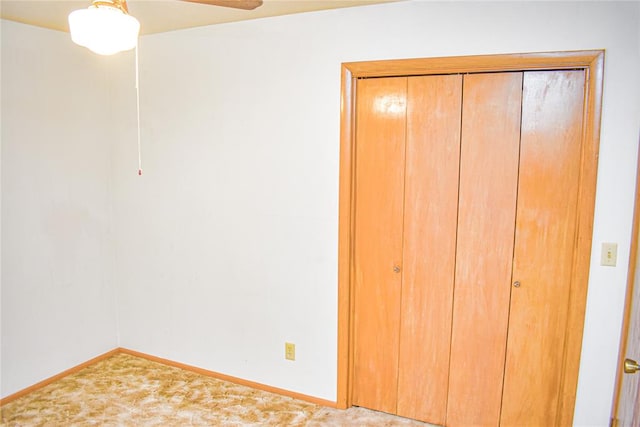 unfurnished bedroom with ceiling fan and a closet