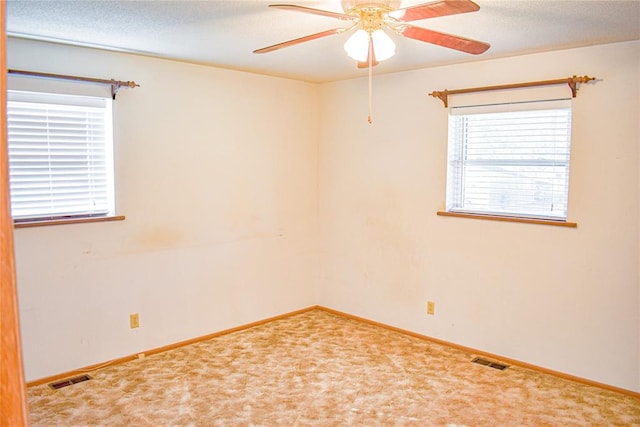 carpeted empty room featuring ceiling fan and a textured ceiling