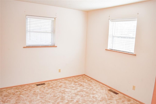 empty room with carpet floors and plenty of natural light