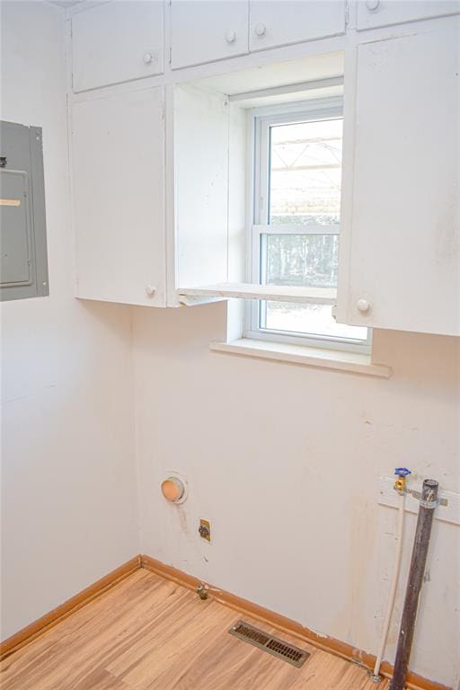 laundry room featuring hardwood / wood-style flooring and electric panel