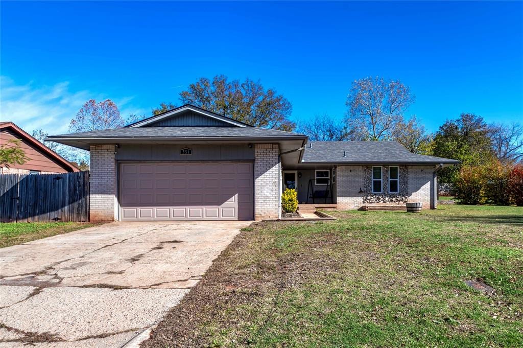 single story home featuring a garage and a front lawn