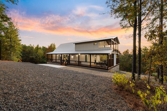 back house at dusk featuring a sunroom