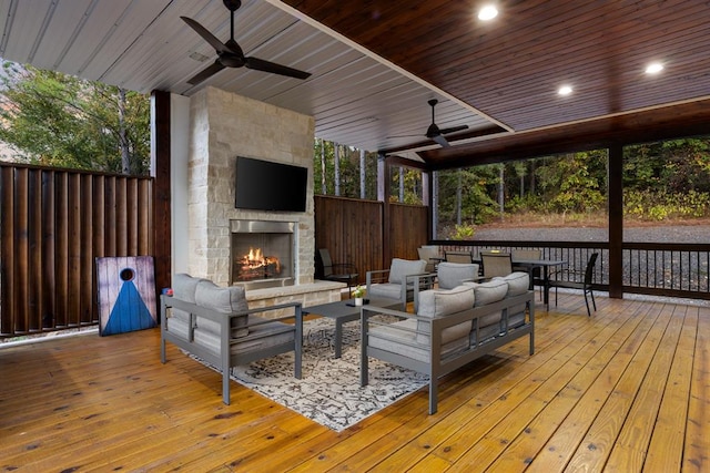 deck with ceiling fan and an outdoor living space with a fireplace