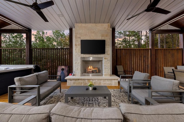 view of patio featuring ceiling fan and an outdoor living space with a fireplace