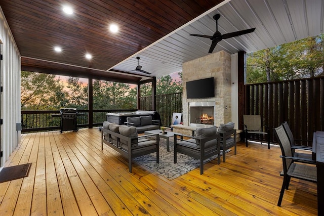 wooden deck featuring ceiling fan, an outdoor living space with a fireplace, and a grill