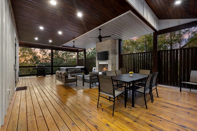 wooden terrace with grilling area, ceiling fan, and an outdoor living space with a fireplace