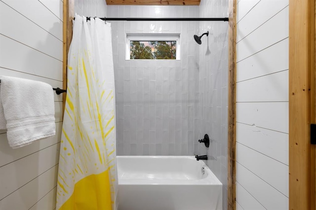 bathroom featuring shower / bathtub combination with curtain and wooden walls