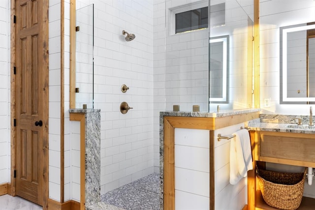 bathroom featuring tiled shower and vanity