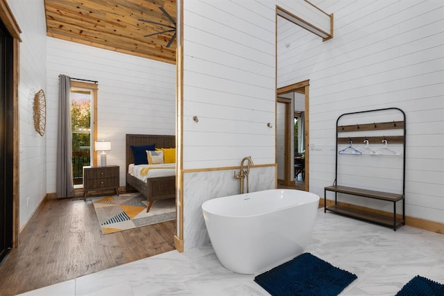 bathroom with a high ceiling, wooden walls, and a washtub