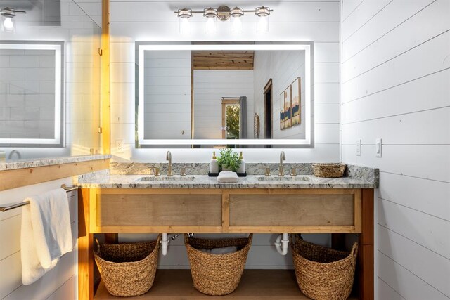 bathroom featuring wooden walls and vanity