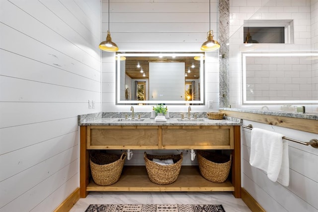 bathroom featuring vanity and wooden walls