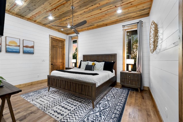 bedroom with hardwood / wood-style flooring, ceiling fan, wooden ceiling, and wooden walls