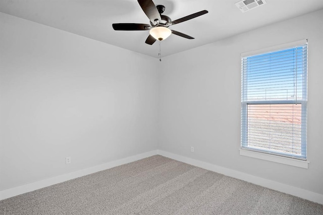 carpeted spare room featuring plenty of natural light and ceiling fan