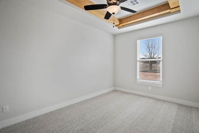 carpeted spare room featuring a tray ceiling and ceiling fan