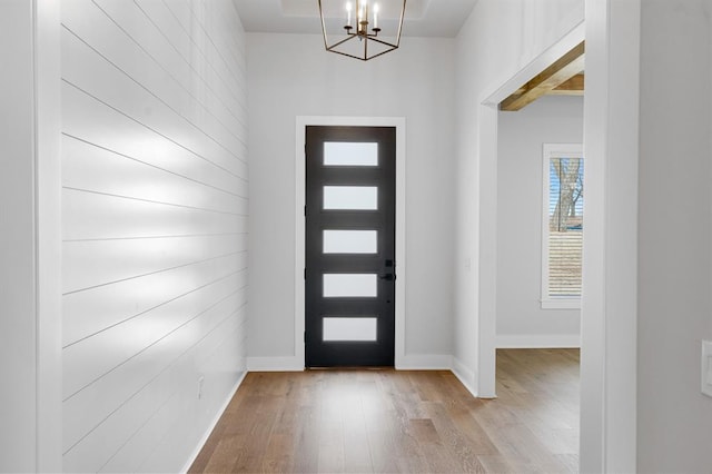 foyer entrance featuring light wood-type flooring and a notable chandelier