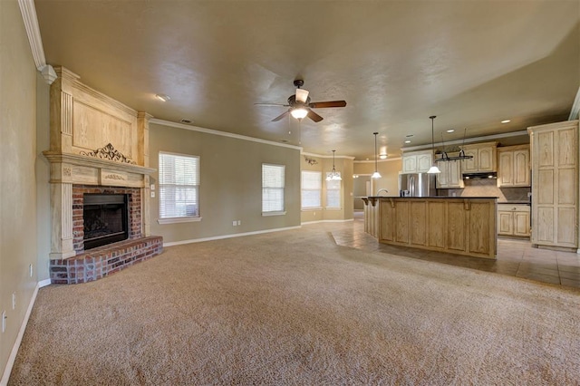 unfurnished living room with crown molding, a fireplace, ceiling fan, and light carpet