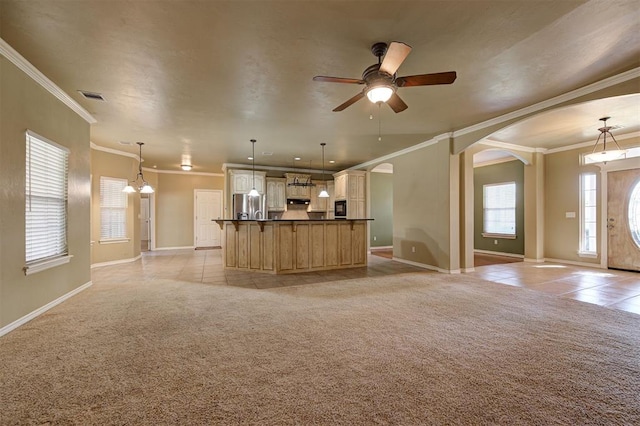 kitchen with decorative light fixtures, crown molding, stainless steel refrigerator, and light carpet