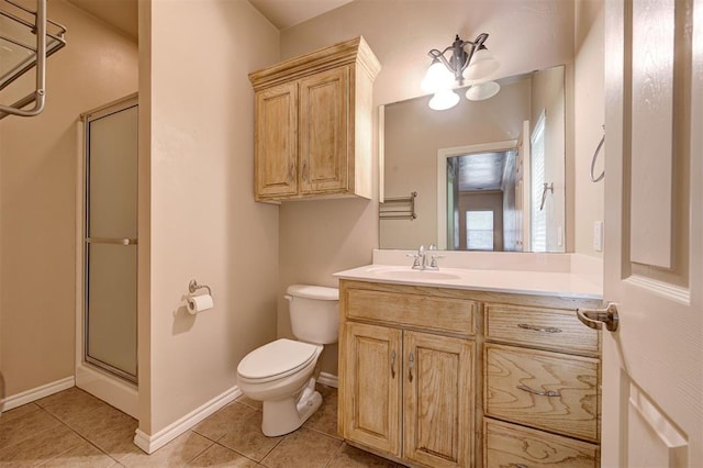 bathroom featuring toilet, a shower with door, vanity, and tile patterned flooring