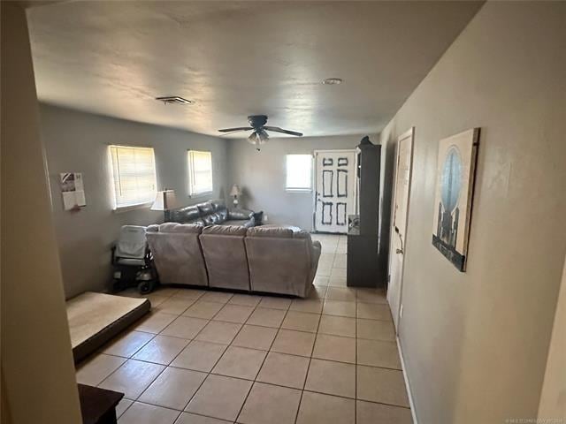 tiled living room with ceiling fan